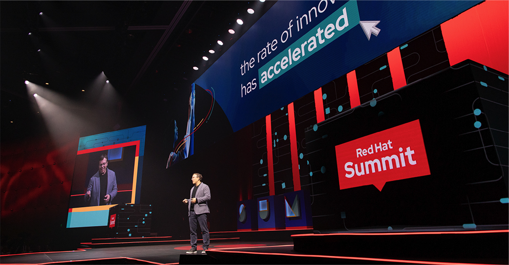 A photo shows Red Hat CEO Matt Hicks presenting at Red Hat Summit.