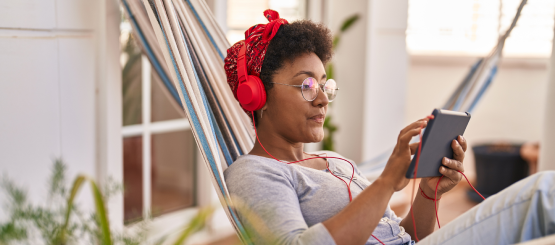 Woman using a tablet while lounging in a hammock 